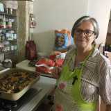 La donna mostra con orgoglio una splendida teglia di pasta al forno con i funghi, pronta per essere messa a cuocere: sar� servita come primo per il pranzo